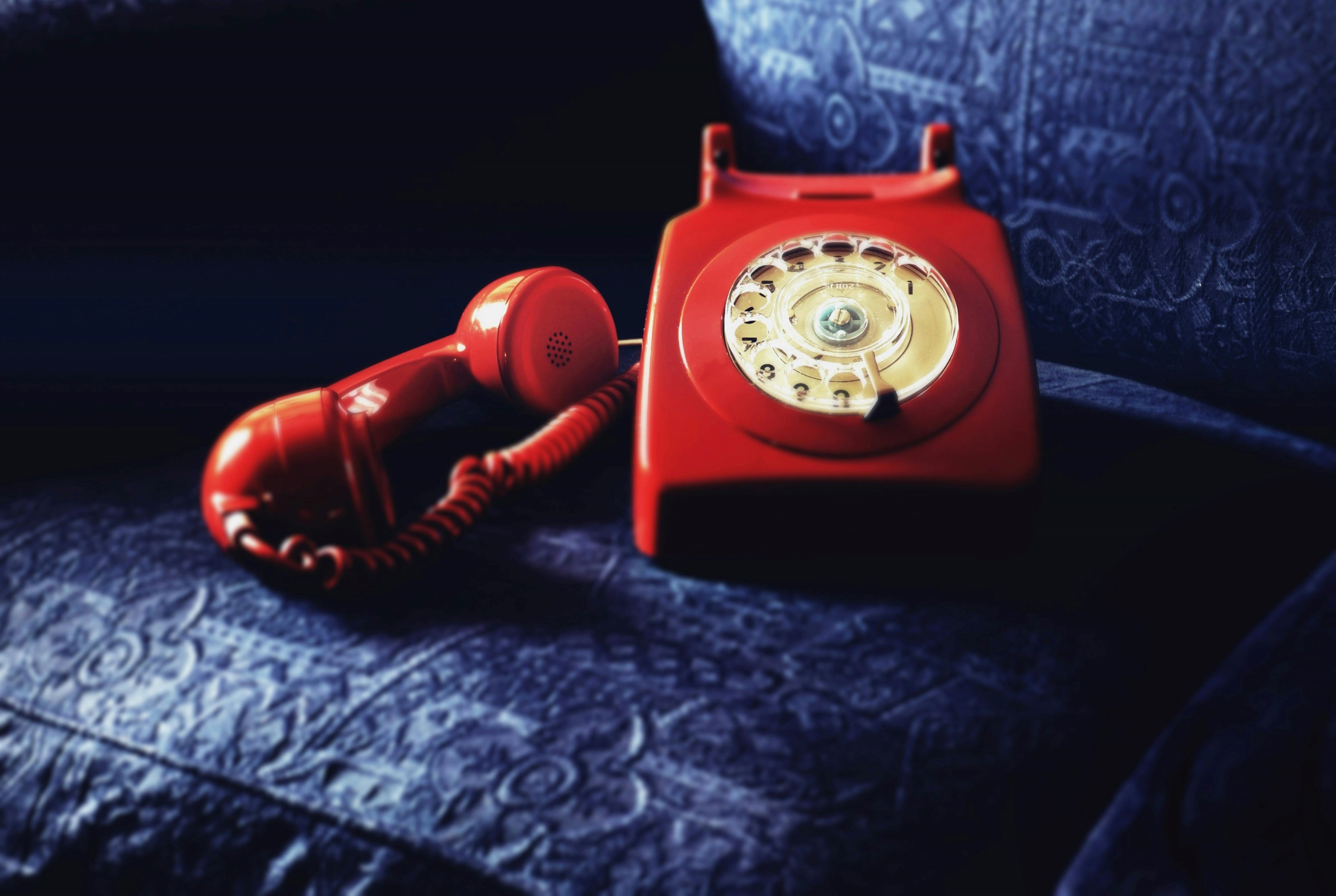 Telefone retro vermelho sobre superfície azul