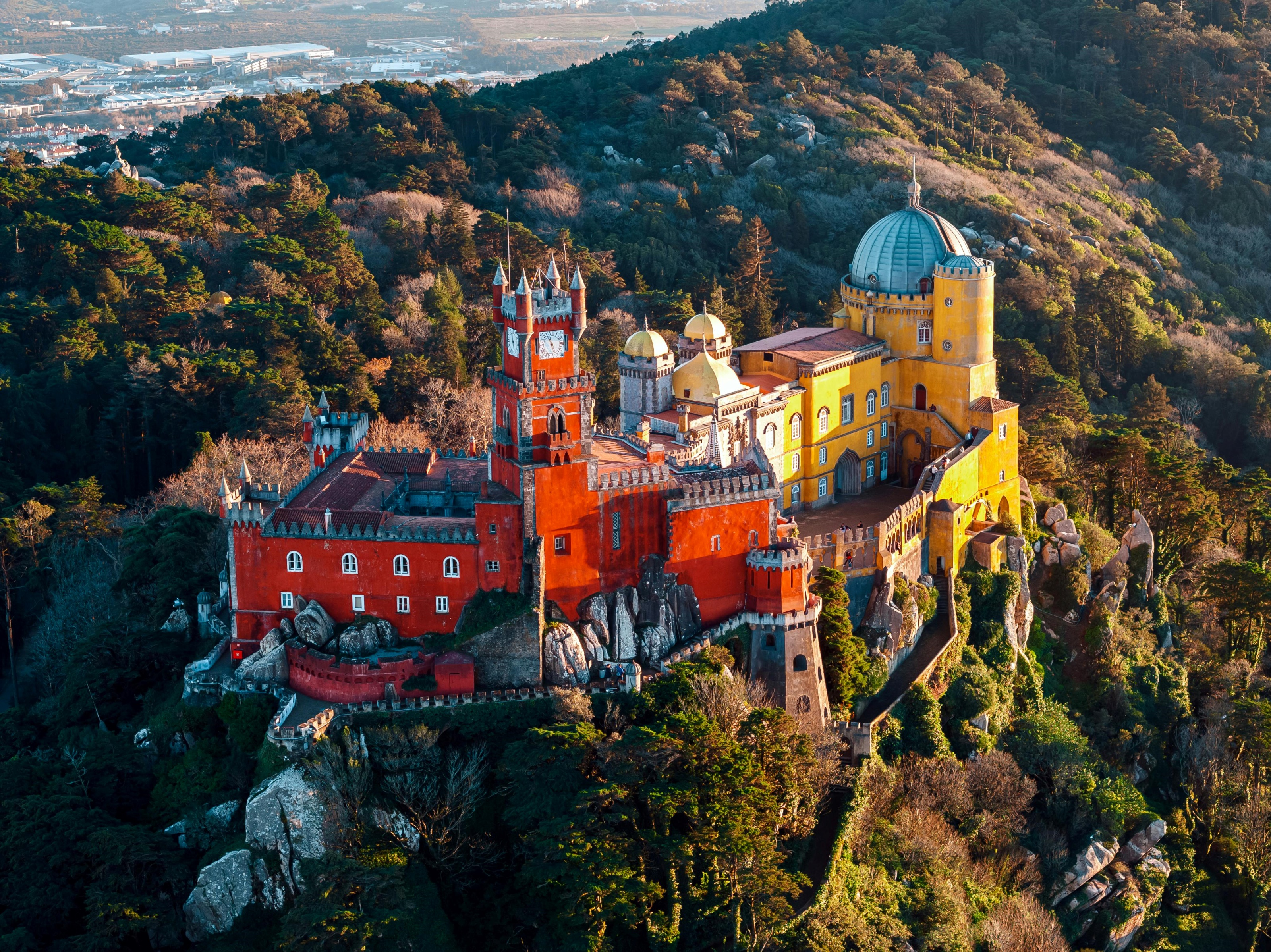 Le Palais de Pena à Sintra se distingue par ses couleurs vives et son architecture romantique. Perché au sommet de la montagne, il offre des vues spectaculaires, entouré d’une nature luxuriante.